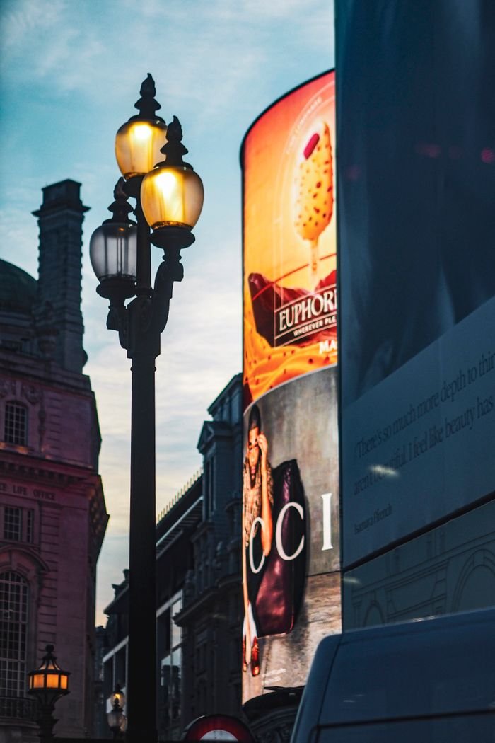 A classic London street scene with vintage lighting and neon ads at twilight, capturing the urban vibe.